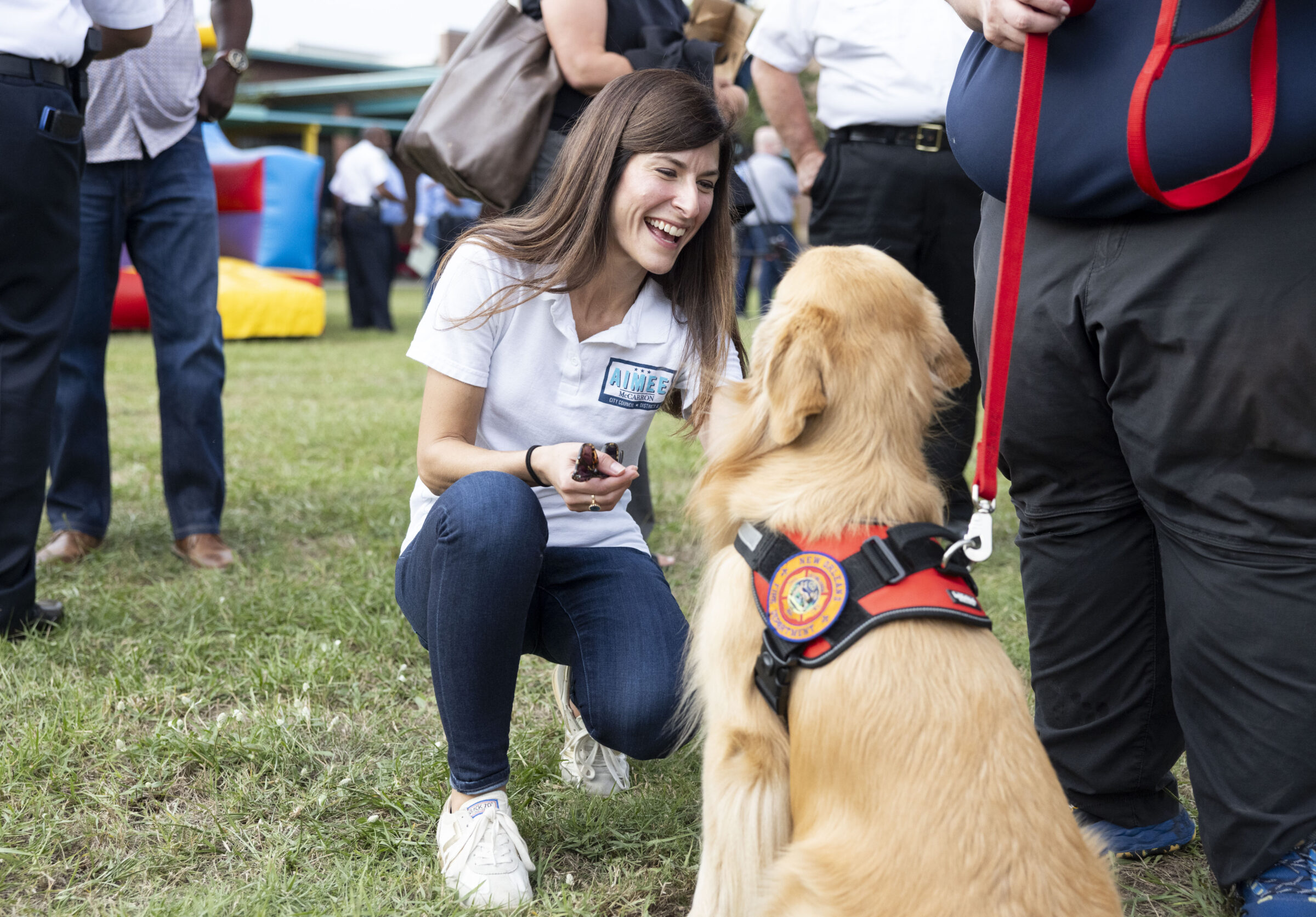 City Council District A candidate Aimee McCarron pets Captain Billy, a NOFD Crisis Response K-9, at the New Orleans Night Out Against Crime at Rosenwald Recreation Center on October 21, 2025.